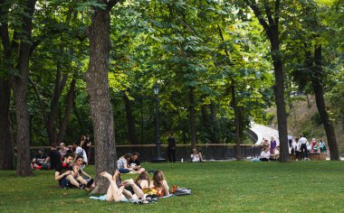 Kyiv, Ukrayna - Haziran. 06, 2019: Volodymyrska Hill veya Kyiv 'deki Saint Volodymyr Hill. Gençler parkta çimlerin üzerinde dinleniyorlar..