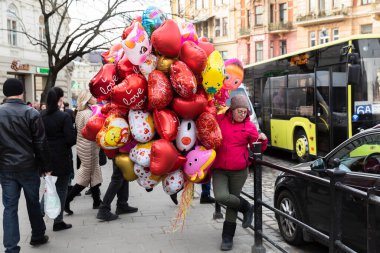 Lviv, Ukrayna - 08 Mar 2019 Lviv caddesi. Eski Lviv şehrinin sokakları ve mimarisi. Kalp şeklinde balonları olan bir kadın.