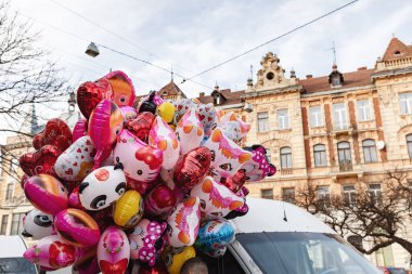 Lviv, Ukrayna - 08 Mar 2019 Lviv caddesi. Eski Lviv şehrinin sokakları ve mimarisi. Kalp şeklinde balonları olan bir kadın.