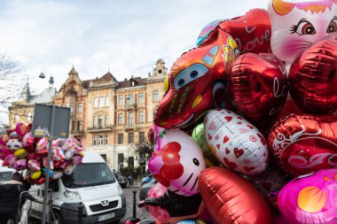 Lviv, Ukrayna - 08 Mar 2019 Lviv caddesi. Eski Lviv şehrinin sokakları ve mimarisi. Kalp şeklinde balonları olan bir kadın.