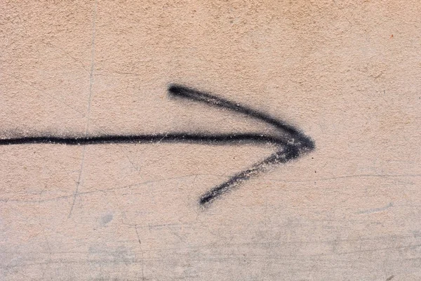 ベージュの壁に描かれた黒い矢印 — ストック写真