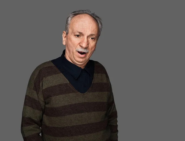 セーターを着た老人があくびをする 灰色の背景のスタジオの肖像 — ストック写真