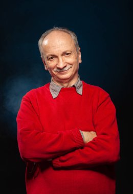 Yaşlı maço adam. Stüdyonun karanlık arka planında yaşlı duygusal bir adamın portresi.