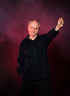 Yaşlı maço adam. Stüdyonun karanlık arka planında yaşlı duygusal bir adamın portresi.