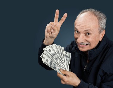 Kıdemli beyefendi bir tomar para tutuyor. Heyecanlı yaşlı bir adamın portresi. Dolarlık banknotlar tutan mutlu yaşlı adam..