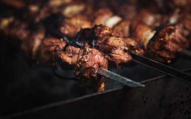 Shashlik yemek pişirme konsepti. Barbeküde ızgara lezzetli yemeklere yakın çekim. Izgarada ızgara şiş kebap.
