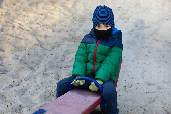 Ένα Τετράχρονο Αγόρι Κάθεται Μια Κούνια Ιατρική Μάσκα Άδειους Δρόμους — Φωτογραφία Αρχείου