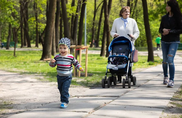 乌克兰基辅 2017年1月1日 快乐的家人在公园散步 祖母和一个婴儿车 女儿和一个小男孩 带着蒲公英在公园的小巷里 — 图库照片