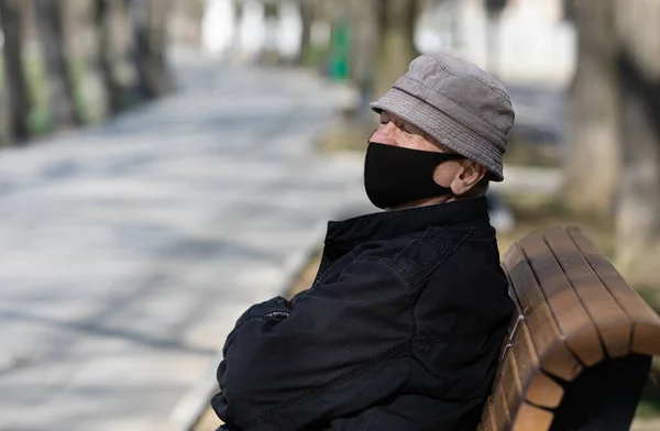 Een Eenzame Bejaarde Man Met Een Medisch Masker Zit Een — Stockfoto