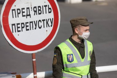 Kyiv, Ukrayna - Nisan. 13, 2020: Ulusal Muhafızlar ve Ukrayna devriye polisi koronavirüs salgını nedeniyle karantina sırasında Kyiv Pechersk Lavra 'nın girişini kontrol ediyorlar. Başlık - Geçişi Göster
