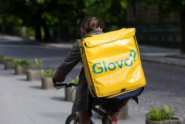 Lviv, Ukrayna - 25 Mayıs 2020: Bir Glovo gıda dağıtım kuryesi Lviv, Ukrayna 'da yemek dağıtıyor.