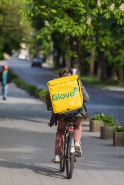 Lviv, Ukrayna - 25 Mayıs 2020: Bir Glovo gıda dağıtım kuryesi Lviv, Ukrayna 'da yemek dağıtıyor.