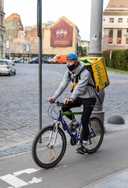 Lviv, Ukrayna - 25 Mayıs 2020: Bir Glovo gıda dağıtım kuryesi Lviv, Ukrayna 'da yemek dağıtıyor.