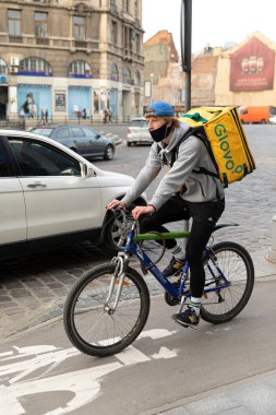 Lviv, Ukrayna - 25 Mayıs 2020: Bir Glovo gıda dağıtım kuryesi Lviv, Ukrayna 'da yemek dağıtıyor.