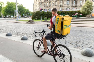 Lviv, Ukrayna - 25 Mayıs 2020: Bir Glovo gıda dağıtım kuryesi Lviv, Ukrayna 'da yemek dağıtıyor.