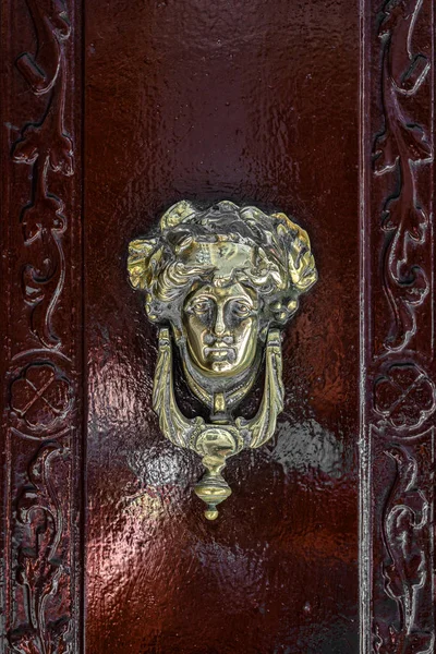 Γυναικείο κεφάλι πόμολο της πόρτας, vintage κόκκινη πόρτα, εξωτερικό — Φωτογραφία Αρχείου