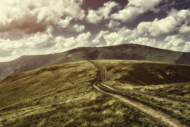 Sonbahar manzara. Karpat Dağları, sonbahar görünümü altında bulutlu gün batımı. Dağ yolundan günbatımı manzara tepenin üstüne gider.