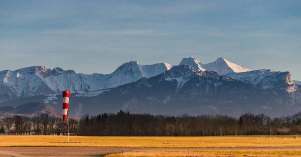 Kleiner Flugplatz vor dem Berggipfel. Sonnenuntergang über den Bergen. — Stockfoto