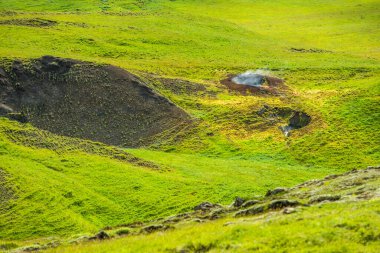Muhteşem İzlanda doğa manzarası. Yukarıdan bak. Yüksek dağlar, dağ nehri ve yeşil çayırlar. Yeşil çayırlar. İzlanda.