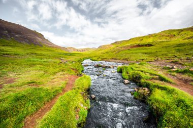 Muhteşem İzlanda doğa manzarası. Yukarıdan bak. Yüksek dağlar, dağ nehri ve yeşil çayırlar. Yeşil çayırlar. İzlanda.