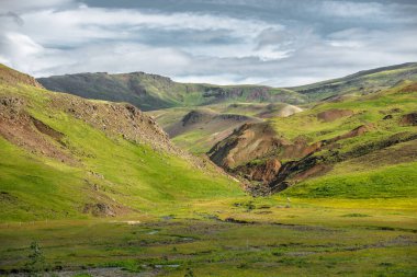 Muhteşem İzlanda doğa manzarası. Yukarıdan bak. Yüksek dağlar, dağ nehri ve yeşil çayırlar. Yeşil çayırlar. İzlanda.