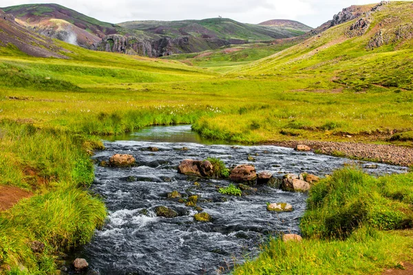 Wunderbare isländische Naturlandschaft. Blick von oben. Hohe Berge, Gebirgsfluss und grüne Wiesen. Grüne Wiesen. Island. — Stockfoto