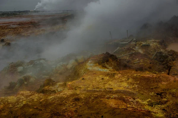 The colorful landscape at the geothermal area. Hot sulfuric steam vent spewing sulphur steam in the hot geothermal area Iceland. Color and mineral rich textured muddy ground in front. — Stock Photo, Image