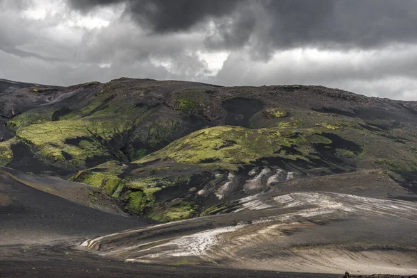 素晴らしいアイスランドの自然景観。高い山、雪、黒い火山砂、山の過酷な道路と緑の草原. — ストック写真