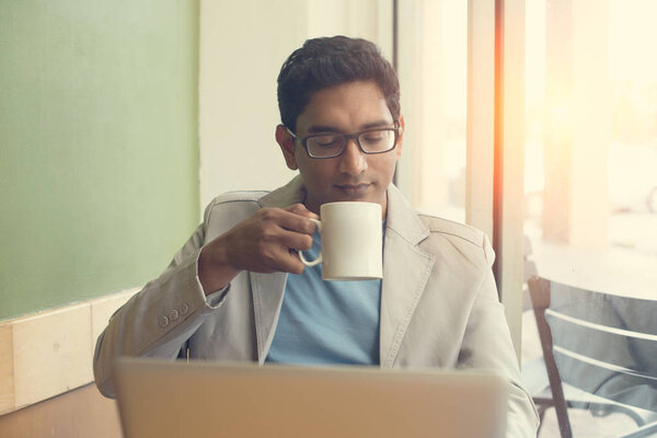 indian male drinking coffe at cafe