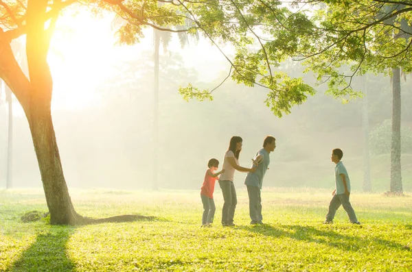Счастливая молодая семья веселится на природе летом — стоковое фото