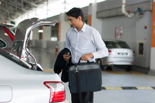 Empresario poniendo caso en el coche — Foto de Stock