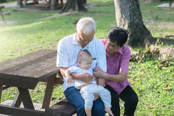 Abuelos chinos sosteniendo nieta — Foto de Stock