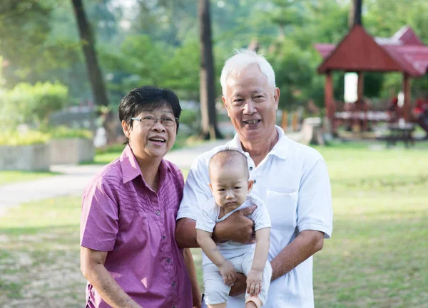 Abuelos chinos sosteniendo nieta —  Fotos de Stock