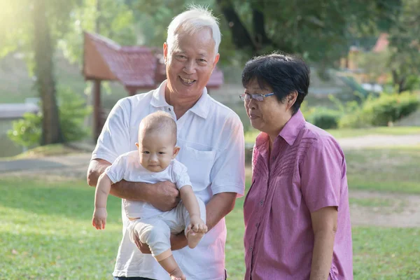 Abuelos chinos sosteniendo nieta — Foto de Stock