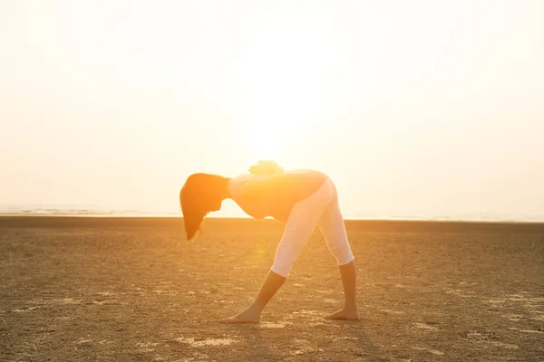 Gravid mamma utför yoga på stranden — Stockfoto
