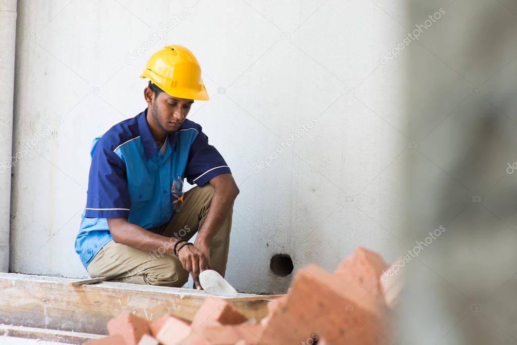 contruction worker laying bricks