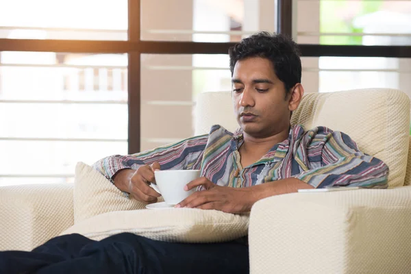 Mann trinkt Kaffee auf Sofa — Stockfoto