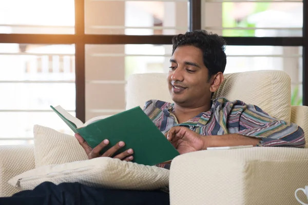 Mężczyzna czyta książkę na sofie — Zdjęcie stockowe