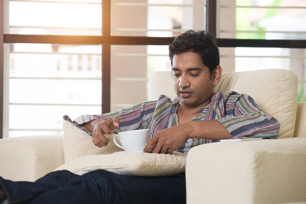 Чоловік п'є каву на дивані — стокове фото