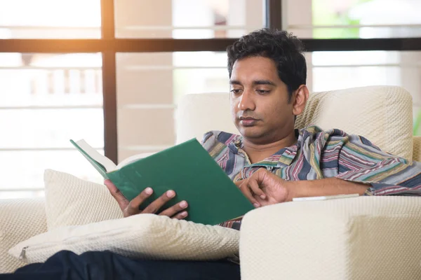 Uomo lettura libro sul divano — Foto Stock