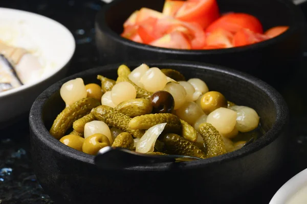 Оливки з цибулею та огірками в мисці — стокове фото