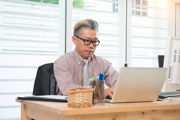 Senior asiatischer Geschäftsmann bei der Arbeit — Stockfoto