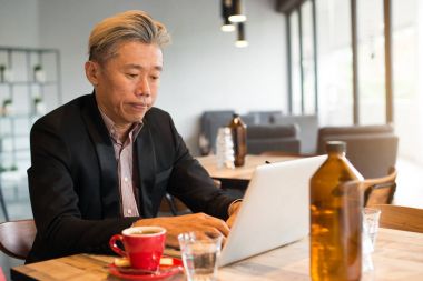 Asya iş adamı kullanarak dizüstü bilgisayar