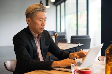 Asya iş adamı kullanarak dizüstü bilgisayar