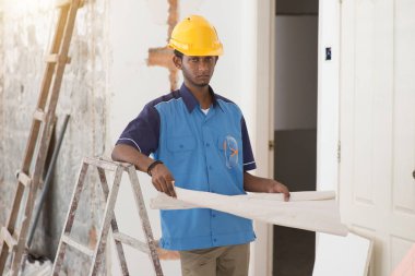 İnşaat işçisi planlara bakıyor.