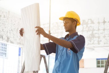 İnşaat işçisi planlara bakıyor.