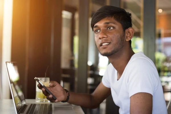 Uomo utilizzando smartphone e laptop — Foto Stock