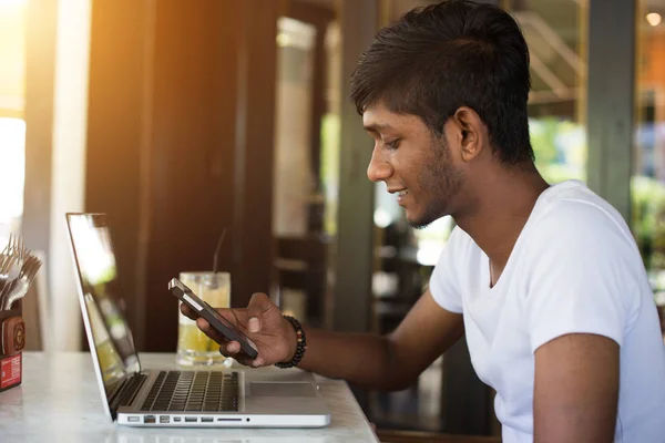 Człowiek za pomocą smartphone i laptopa — Zdjęcie stockowe