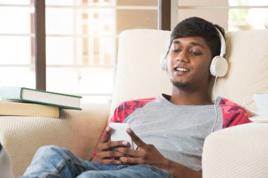 Indian teenage guy listening to music clipart