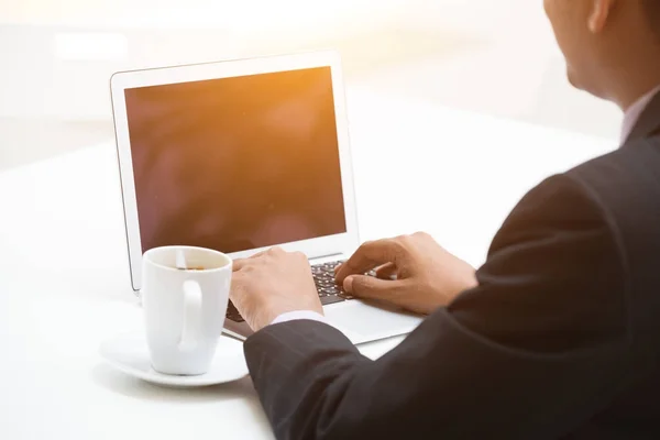 Geschäftsmann arbeitet mit Laptop und trinkt Kaffee — Stockfoto